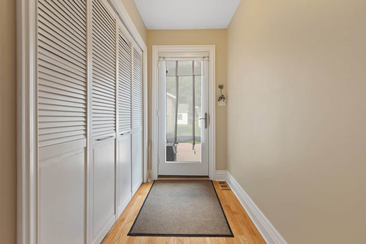 a hallway with a door and a rug on the floor